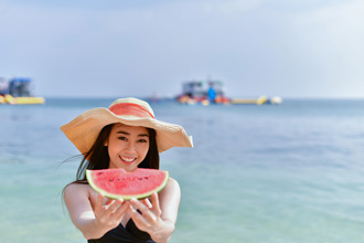 海でスイカをくれる女性