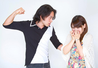 女性を殴りつけようとしている男性