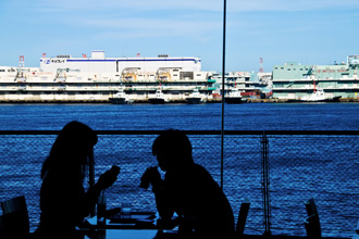 カップルが海沿いのテラスでカフェデート