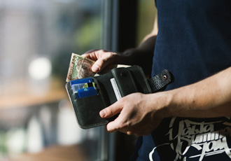 男性が財布からお金を出して支払いしている