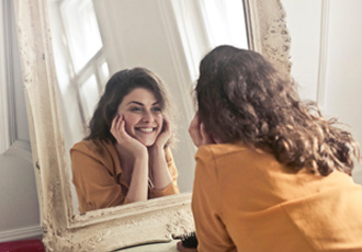 鏡に向かって微笑む女性