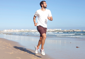 海辺をランニングする男性