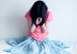 女性が手で顔を覆い泣いている