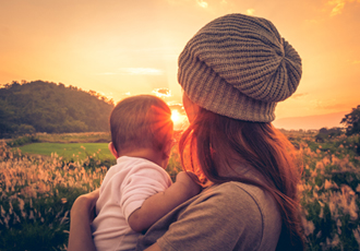 母子が夕陽を見つめている背中