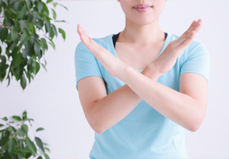 女性が胸元で腕をクロスして拒絶のポーズをしている