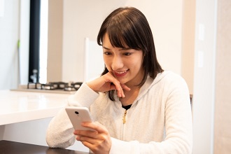 スマートフォンを見て笑顔の女性